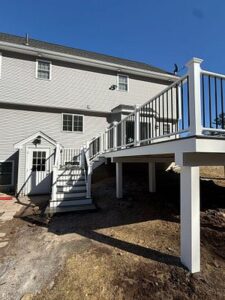 Custom Deck Construction featuring a high-level deck with integrated staircase and black metal railings.